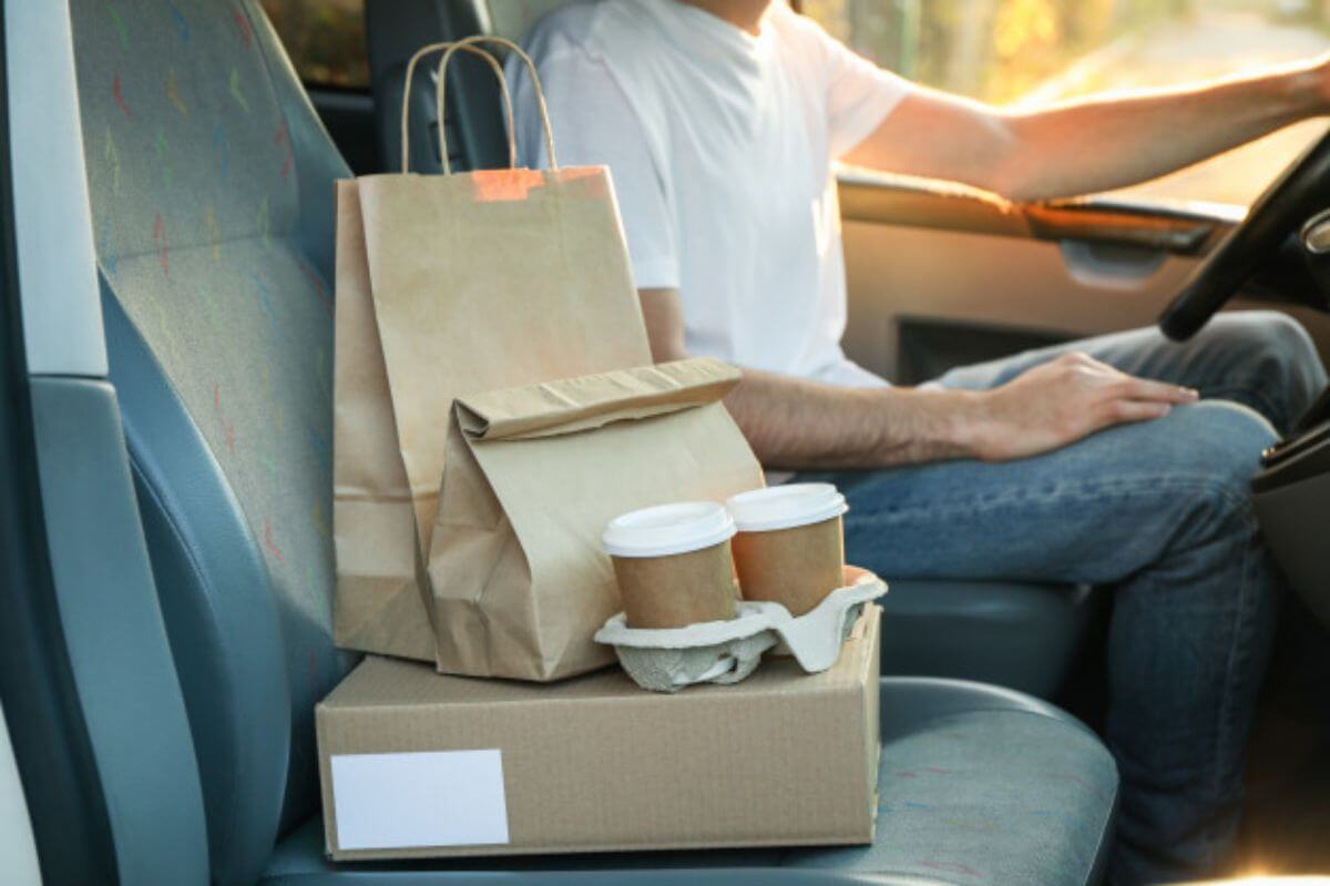 Courier car delivery with boxes and coffee cups ready for drop-off